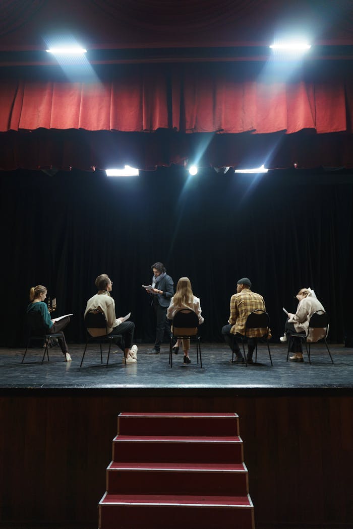 A group of actors rehearsing on stage under spotlights, creating an immersive theater experience.